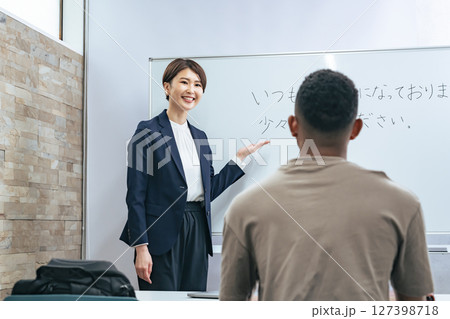 黒人男性に日本語学校でビジネス用語を教える女性教師 127398718