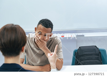 悩む黒人男性と面談する日本人女性スタッフ 127398721