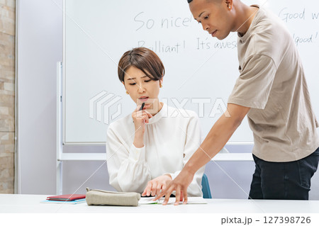 教室で会話する黒人男性と日本人女性 教室で会話する黒人男性と日本人女性 127398726