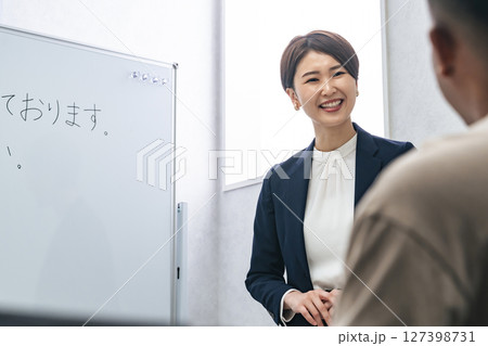 黒人男性に日本語学校でビジネス用語を教える女性教師 127398731