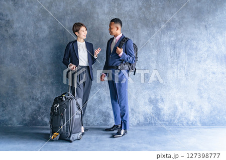 旅行の荷物を持つ黒人男性ビジネスマンと日本人女性スタッフ 旅行の荷物を持つ黒人男性ビジネスマンと日本人女性スタッフ 127398777