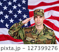 American male soldier in uniform saluting on a background USA flag. 127399276