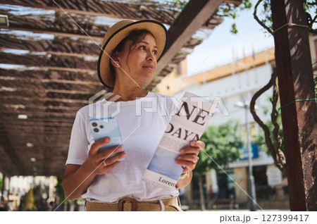 Woman Touring Historic Streets With Map and Smartphone Guide in a Sunny Urban Setting 127399417