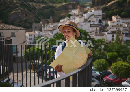 Smiling Female Tourist with Map Exploring a Historic Mediterranean Village Smiling Female Tourist with Map Exploring a Historic Mediterranean Village 127399427