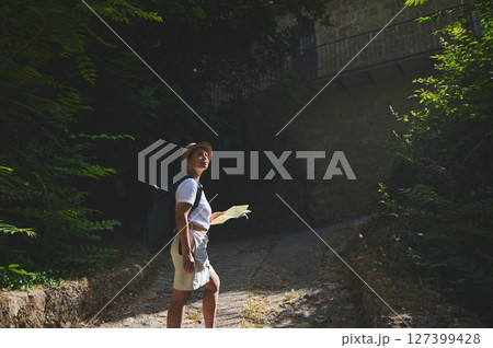 Woman Exploring a Historic Stone City Street with Map 127399428