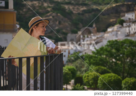 Woman Exploring a Historic City Landscape With a Tourist Map in Hand 127399440