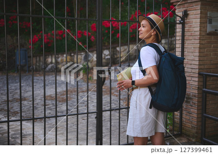 Woman Tourist Exploring Historic City with Backpack and Map Near Ornate Gate 127399461
