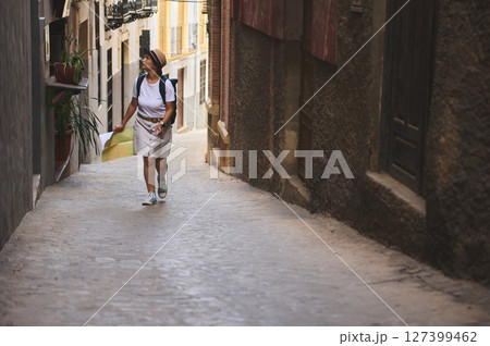 Woman Exploring Historic Streets of a Quaint European Village Woman Exploring Historic Streets of a Quaint European Village 127399462