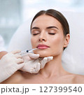 Cosmetologist injecting silicone in lips. Cosmetology treatment close up. Skin care procedures in the beauty salon. Facial rejuvenation. 127399540