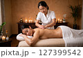 Asian woman having a back massage at a cosmetology and body care spa center. 127399542