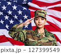 Asian american female soldier in uniform saluting on a background USA flag. 127399549