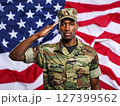 African american male soldier in uniform saluting on a background USA flag. 127399562
