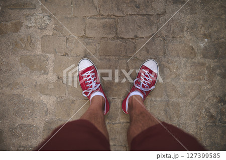 Casual Red Sneakers on Cobblestone Path Capturing Urban Exploration Mood Casual Red Sneakers on Cobblestone Path Capturing Urban Exploration Mood 127399585