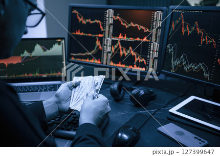 Financial Analyst Working on a Computer with Multi-Monitor Workstation with Real-Time Stocks, Commodities and Exchange Market Charts. Financial Analyst Working on a Computer with Multi-Monitor Workstation with Real-Time Stocks, Commodities and Exchange Market Charts. 127399647
