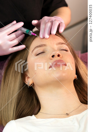 Woman undergoing non-surgical facial peel treatment with syringe Woman undergoing non-surgical facial peel treatment with syringe 127400035