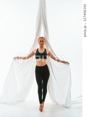 Young beautiful woman doing fly yoga against white background 127400192