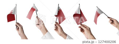 The Bahrain flag in hand in different angles on a white background 127400206