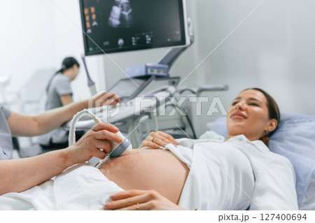 Close up view, scanning. Pregnant woman is lying down in the hospital, doctor does ultrasound 127400694