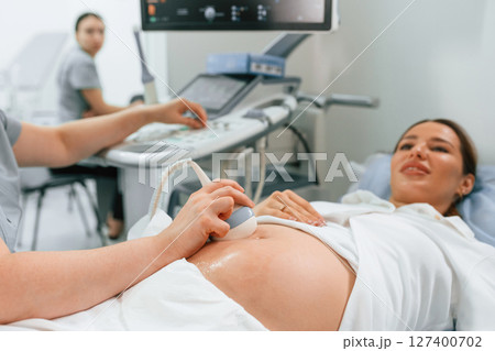 Focused close up view. Pregnant woman is lying down in the hospital, doctor does ultrasound 127400702