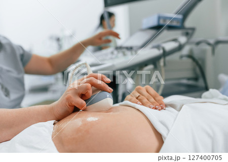 Focused close up view. Pregnant woman is lying down in the hospital, doctor does ultrasound 127400705