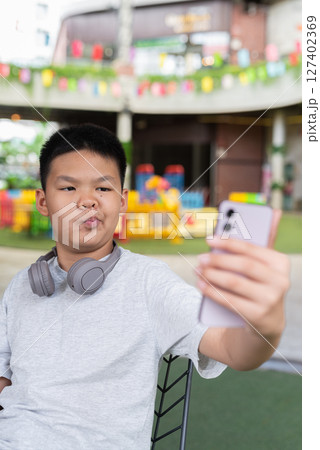 Young teenager boy taking selfie with mobile phone 127402369