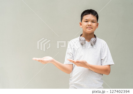Thai Boy Portrait Against Plain Wall in Natural Light 127402394