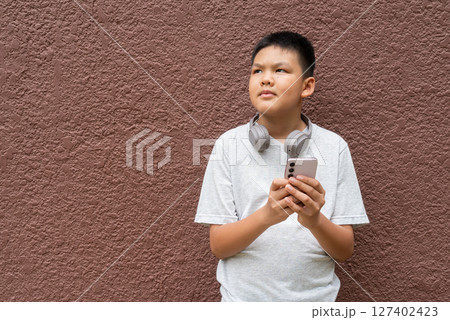 Teenager Boy Portrait Against Plain Wall in Natural Light 127402423