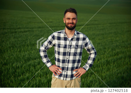 On agricultural field. Handsome young man 127402518