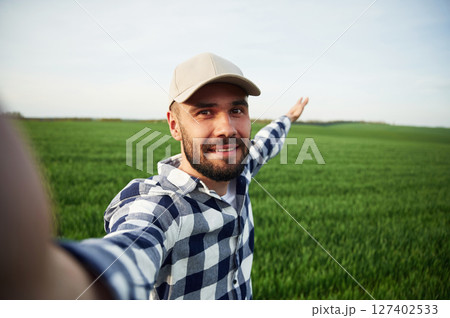 Making selfie. Handsome young man is on agricultural field Making selfie. Handsome young man is on agricultural field 127402533