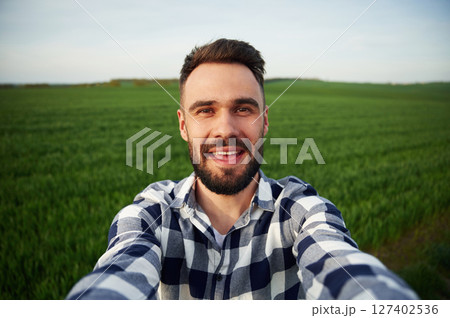 Making selfie. Handsome young man is on agricultural field Making selfie. Handsome young man is on agricultural field 127402536