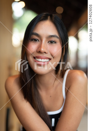 Portrait of beautiful young woman in coffee shop 127402608