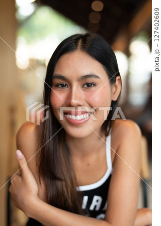 Portrait of beautiful young woman in coffee shop 127402609
