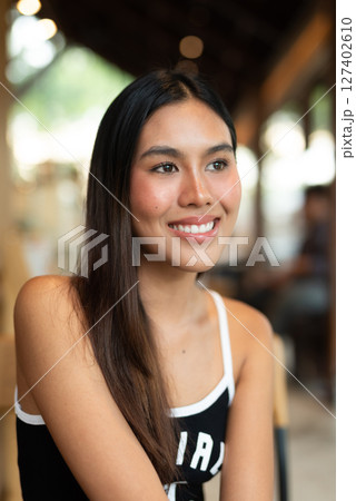 Portrait of beautiful young woman in coffee shop 127402610