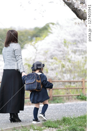桜と入園式を迎えた3歳の女の子と母親 127403941