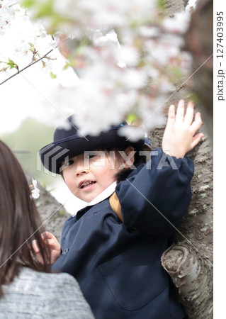 桜と入園式を迎えた3歳の女の子と母親 127403995