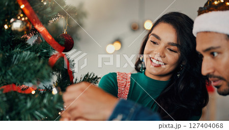 Christmas, home and couple with tree, help and bonding together with love, romance and relationship. Happy people, apartment and man with woman, Xmas and marriage with celebration, tradition or smile 127404068