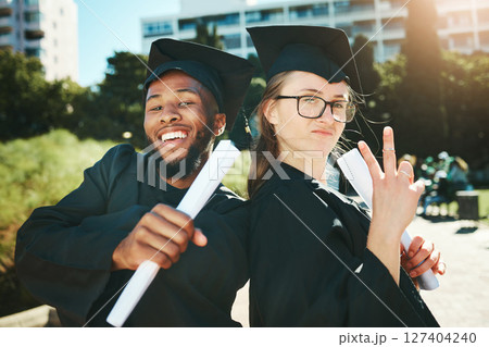 Graduation, students and happy for success, achievement or silly together outdoor. Portrait, man and woman smile, for completed degree and in gown for education, certificate and diploma at university Graduation, students and happy for success, achievement or silly together outdoor. Portrait, man and woman smile, for completed degree and in gown for education, certificate and diploma at university 127404240