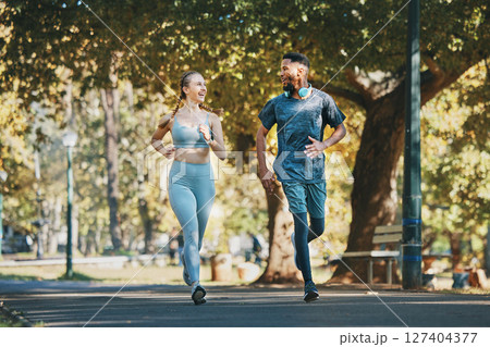 Running, exercise and fitness with a diversity couple in the park for a cardio workout together. Training, motivation and run with a man and woman athlete bonding while exercising outside in the day Running, exercise and fitness with a diversity couple in the park for a cardio workout together. Training, motivation and run with a man and woman athlete bonding while exercising outside in the day 127404377