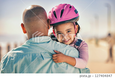 Father, bicycle and girl portrait of a young kid with a helmet by the sea ready for cycling learning. Family, holiday and fun of a dad and child hug with happiness and bike gear excited for activity Father, bicycle and girl portrait of a young kid with a helmet by the sea ready for cycling learning. Family, holiday and fun of a dad and child hug with happiness and bike gear excited for activity 127404847