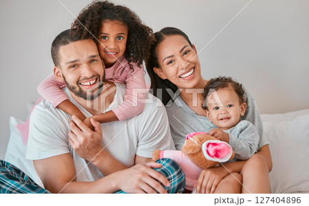 Bonding, care and smile from family in the bedroom with love, peace and relax together in the morning. Happy, affection and portrait of a mother and father with their girl children in bed for rest Bonding, care and smile from family in the bedroom with love, peace and relax together in the morning. Happy, affection and portrait of a mother and father with their girl children in bed for rest 127404896