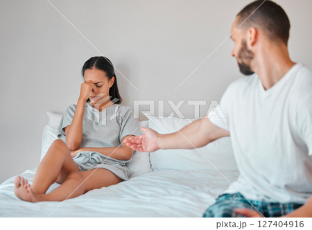Comfort, crying and sad couple in bed after fight, argument and disagreement at home. Love, marriage and young man reaching to console upset and depressed woman sitting in bedroom to fix relationship 127404916