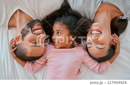 Happy, love and family relaxing on the bed together in a bedroom of their house to bond and relax. Happiness, smile and parents lying, talking and bonding with their girl child in room at their home. Happy, love and family relaxing on the bed together in a bedroom of their house to bond and relax. Happiness, smile and parents lying, talking and bonding with their girl child in room at their home. 127404926