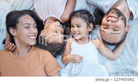 Happy family, love and care of parents for children lying on a blanket for bonding, quality time and support. Black man, woman and kids from top together on a picnic for fun, relax and portrait 127405061