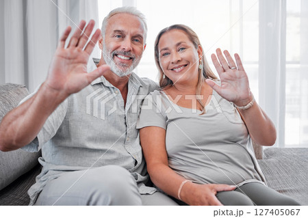 Elderly couple, relax and smile in hello for introduction, waving hands or video call on living room sofa at home. Portrait of happy senior man and woman smiling in happiness for communication 127405067