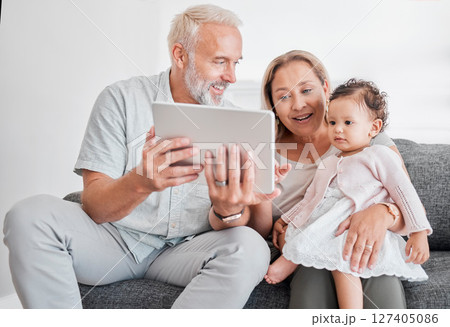 Grandparents, baby girl and tablet learning on living room sofa for online games, watching cartoons and relax at home. Happy family, grandmother and grandpa play with child on digital educational app 127405086