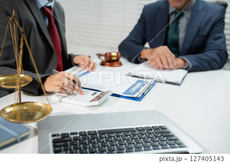 Teamwork of business lawyer meeting working hard about legal legislation in courtroom to help their customer. 127405143