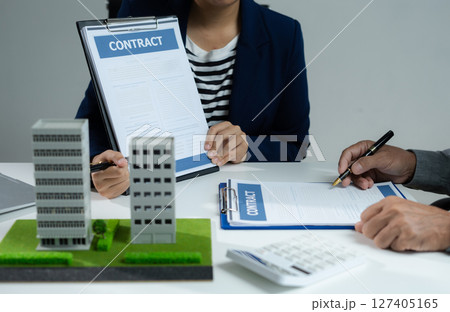 House model with agent asking costumer for contract to buy, get insurance or loan real estate or property. 127405165