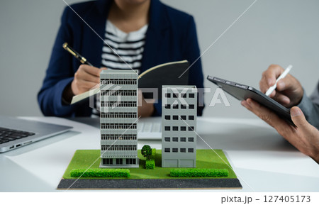House model with agent asking costumer for contract to buy, get insurance or loan real estate or property. 127405173