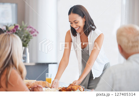 Happy woman hosting food at dinner table in home, house and dining room for family lunch, meal and social gathering together. Party, celebration and eating in family home, lifestyle and happiness Happy woman hosting food at dinner table in home, house and dining room for family lunch, meal and social gathering together. Party, celebration and eating in family home, lifestyle and happiness 127405314