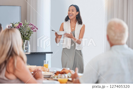 Woman, excited and serving family at thanksgiving dining table in house or home for celebration event, holiday or buffet party. Smile, happy or festive person with healthy food, meal or brunch bowl Woman, excited and serving family at thanksgiving dining table in house or home for celebration event, holiday or buffet party. Smile, happy or festive person with healthy food, meal or brunch bowl 127405320